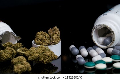 Big Pharmaceutical Pills And Capsules Compared Or Versus All Natural Marijuana Legalization Recreational And Medical Cannabis On Mirrored Black Reflection Background