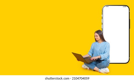 Big phone behind woman. Girl is sitting with laptop. Big blank smartphone. Layout for application. Female student on yellow background. Screen of giant mobile phone. Template for educational ads