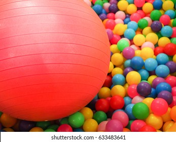 Big Pink Exercise Ball On Colorful Small Balls As Background