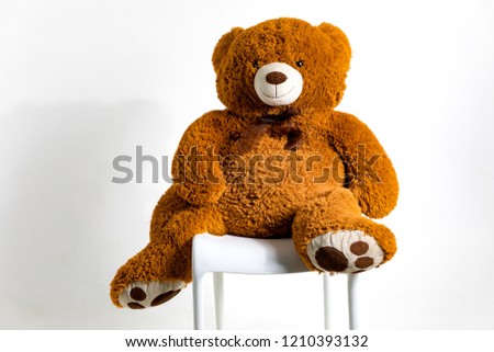 Big plush bear sitting on a chair