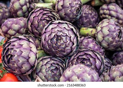 Big purple globe artichokes heads vegetables on farmers market in Brittany, France - Powered by Shutterstock