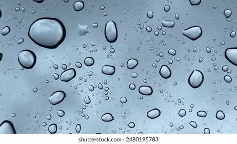 Big rain drops on the window after the rain, through which you can see the gloomy sky. Gloomy weather of approaching storm. Moody weather - Powered by Shutterstock