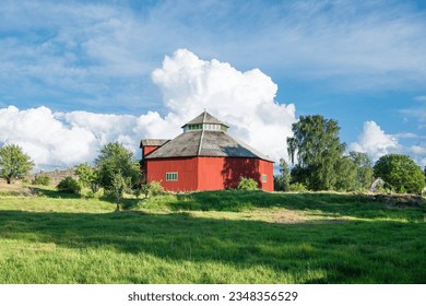 Big red barn with big clouds