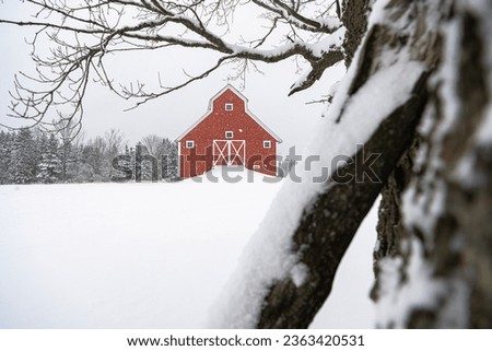 A big red barn in snow covered field