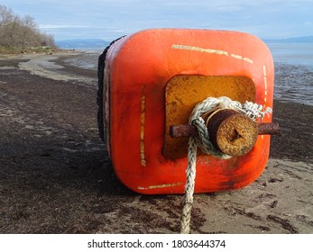 big red buoy on a sandy beach