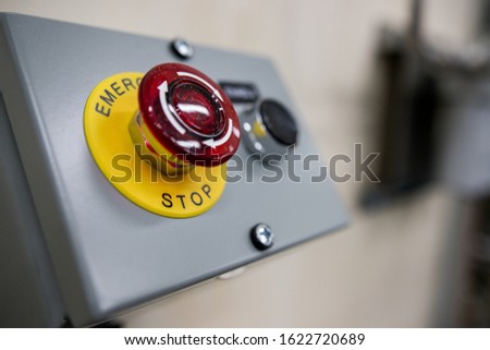 Big Red emergency button or stop button for manual pressing. STOP button for industrial equipment, emergency stop. Red light. At the factory and industrial facility