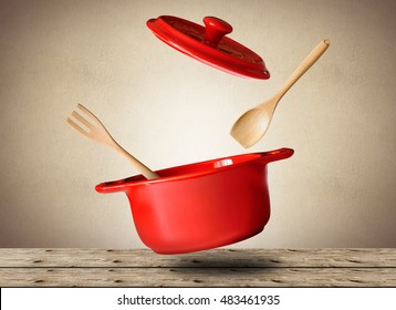 Большой красный горшок для супа с ложкой и вилкой