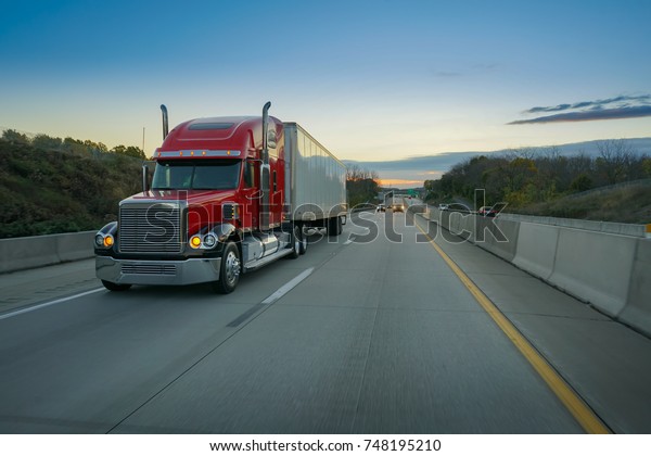 Big red semi truck on\
highway
