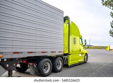 Big Rig Classic Bonnet Industrial Diesel Semi Truck With Refrigerator Semi Trailer Running On The Truck Stop Parking Lot Past Other Parked Trucks Looking For Empty Reserved Parking Spot