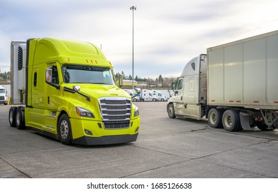 Big Rig Classic Bonnet Industrial Diesel Semi Truck With Refrigerator Semi Trailer Running On The Truck Stop Parking Lot Past Other Parked Trucks Looking For Empty Reserved Parking Spot