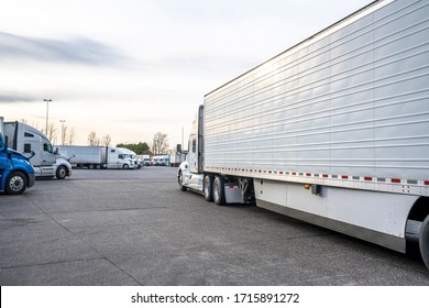 Big Rig Classic Bonnet Industrial Diesel Semi Truck With Refrigerator Semi Trailer Running On The Truck Stop Parking Lot Past Other Parked Trucks Looking For Empty Reserved Parking Spot