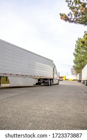 Big Rig Classic Bonnet Industrial Diesel Semi Truck With Refrigerator Semi Trailer Running On The Truck Stop Parking Lot Past Other Parked Trucks Looking For Empty Reserved Parking Spot