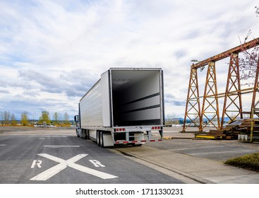 Big Rig Commercial Freights Semi Truck With Empty Refrigerator Semi Trailer With Open Door Standing On The Road Shoulder In Industrial Warehouse Area Waiting For The Next Load For Delivery