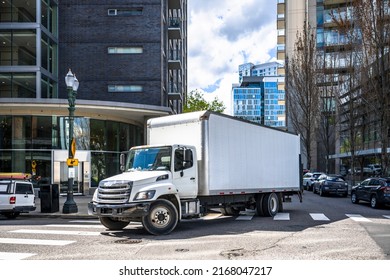 Big rig day cab white semi truck with long box trailer making local commercial delivery at urban city with multilevel residential apartments buildings turning on the city street with crossroad - Shutterstock ID 2168047217