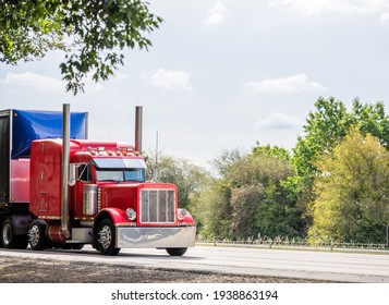 Big Rig Red Classic American Industrial Semi Truck Tractor With Sleeper Cab Compartment For Truck Driver Rest Transporting Cargo In Dry Van Semi Trailer Driving On The Highway Road With Trees