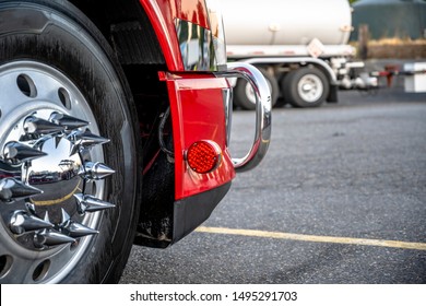 Big Rig Red Heavy-duty Powerful Semi Truck Wheel With Aluminum Rim And Shiny Tire And Chrome Grille Guard Standing On The Truck Stop Parking Lot In Dedicated Spot