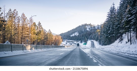 Big Rigs Semi Trucks With Semi Trailers Running Toward Each Other On The Winter Snowy And Icy Highway Road With Exit With Platform For Putting Chains On The Drive Wheels In Mountains Of Montana