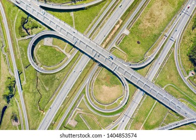 Big Road Junction On Green Land Aerial View. Highway And Half Clover Leaf Junction With Traffic