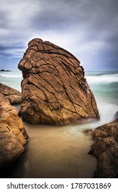 Big Rock On Beach Sand Among Other Rocks