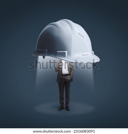 Big safety helmet protecting a corporate businessman using a smartphone: data protection, security and business