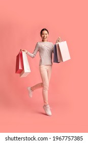 Big Sales Concept. Full Length Shot Of Young Happy Asian Woman Running With Colorful Shopping Bags Over Pink Background, Excited Korean Shopaholic Lady Enjoying Seasonal Discounts, Copy Space