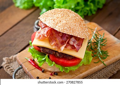 大きなサンドイッチ – ハンバーガーと牛肉、チーズ、トマト、フライドベーコンの写真素材