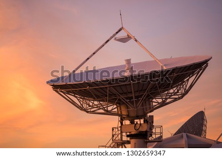 Big satelite dish or antenna against twilight sky at sunset. Telecommunication Technology concept.
