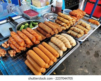 Big sausages street food with sweet spicy sauce and cucumber