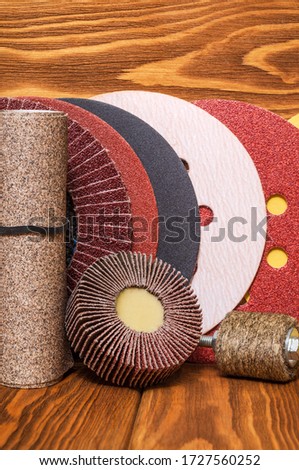 Big set of abrasive tools and multicolored sandpaper on wooden vintage background, wizard is used for grinding items