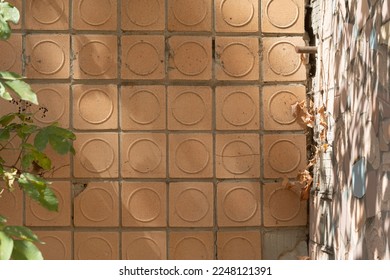 Big shabby textured wall is lined with old Soviet beige crumbling ceramic tiles. Dangerous crumbling facade.