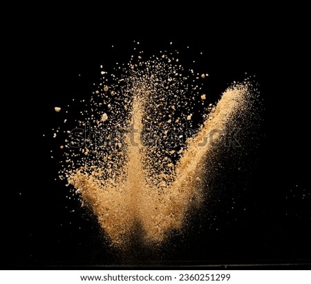 Big size Sand flying explosion, Golden grain wave explode. Abstract cloud fly. Yellow colored sand splash throwing in Air. Black background Isolated selective focus blur