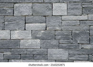 Big and small Bricks in a grey Stone Wall - Shutterstock ID 2163252871