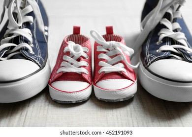 Big And Small Shoes On Wooden Floor, Closeup