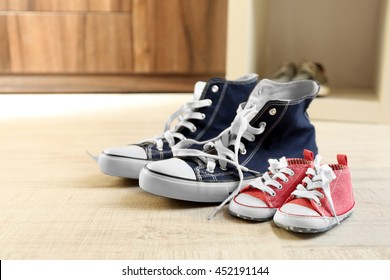 Big And Small Shoes On Wooden Floor