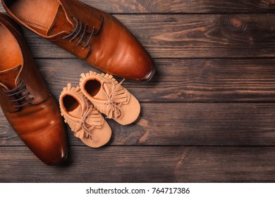 Big And Small Shoes On Wooden Background. Father's Day Composition