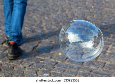 big soap bubble over cobblestone pavement