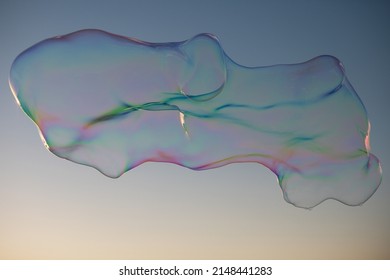 Big Soap Bubbles On Sunset Sky Background.