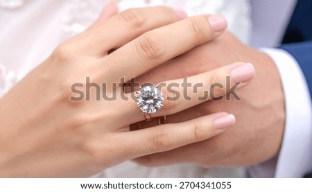 Big Solitaire Diamond Ring on Female Hand while Holding Male Partner Hand