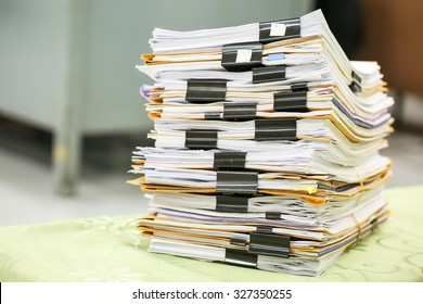 Big stack of business report paper files with black clips