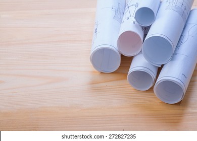 big stack of rolls blueprints on wooden board with organized copyspace 