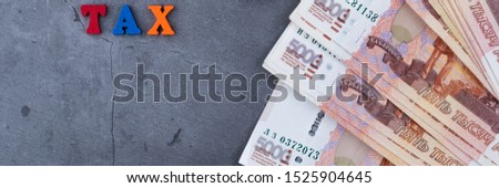 Big stack of Russian money banknotes of five thousand rubles lying fan on a grey cement background.
