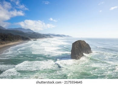 Big Stone In The Sea, Ocean. The Sandy Shore And Mountains Are Visible In The Distance. Blue Sky With Light White Clouds. Beautiful Seascape. There Are No People In The Photo. Nature Background.