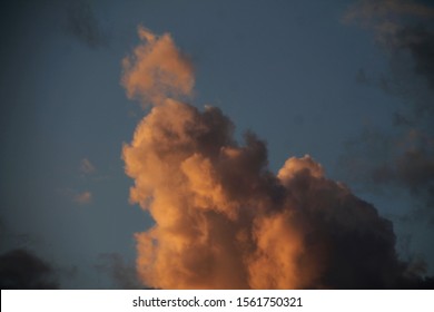 Big Stormy Clouds Lit By The Sun Setting, With A Slight Orange Tint That Reminds A Renaissance Painting