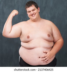 Big, Strong And Sexy. Studio Shot Of An Obese Young Shirtless Man Flexing His Bicep.