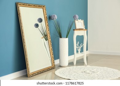 Big Stylish Mirror With Small Table And Vase Near Color Wall In Room