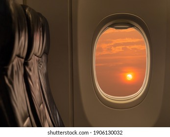 Big sun at sunset sky from airplane window. Travelling by airplane seat near window enjoying beautiful sunset. Sunset through aircraft window.