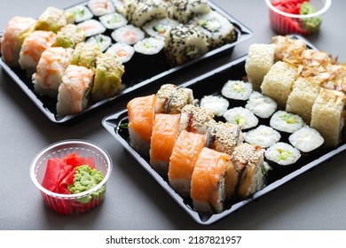 Big Sushi Rolls Set In Black Plastic Box For Take Away On Gray Background