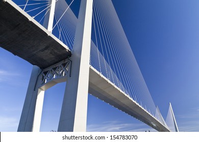 Big suspension bridge in beams the coming sun against the blue sky