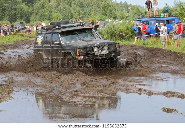 big SUV in the big puddle with mud,  Kyivska\
oblast, Ukraine, summer 2016\
