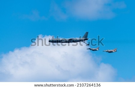 Big tanker army airplane is aerial refueling three fighter aircrafts.